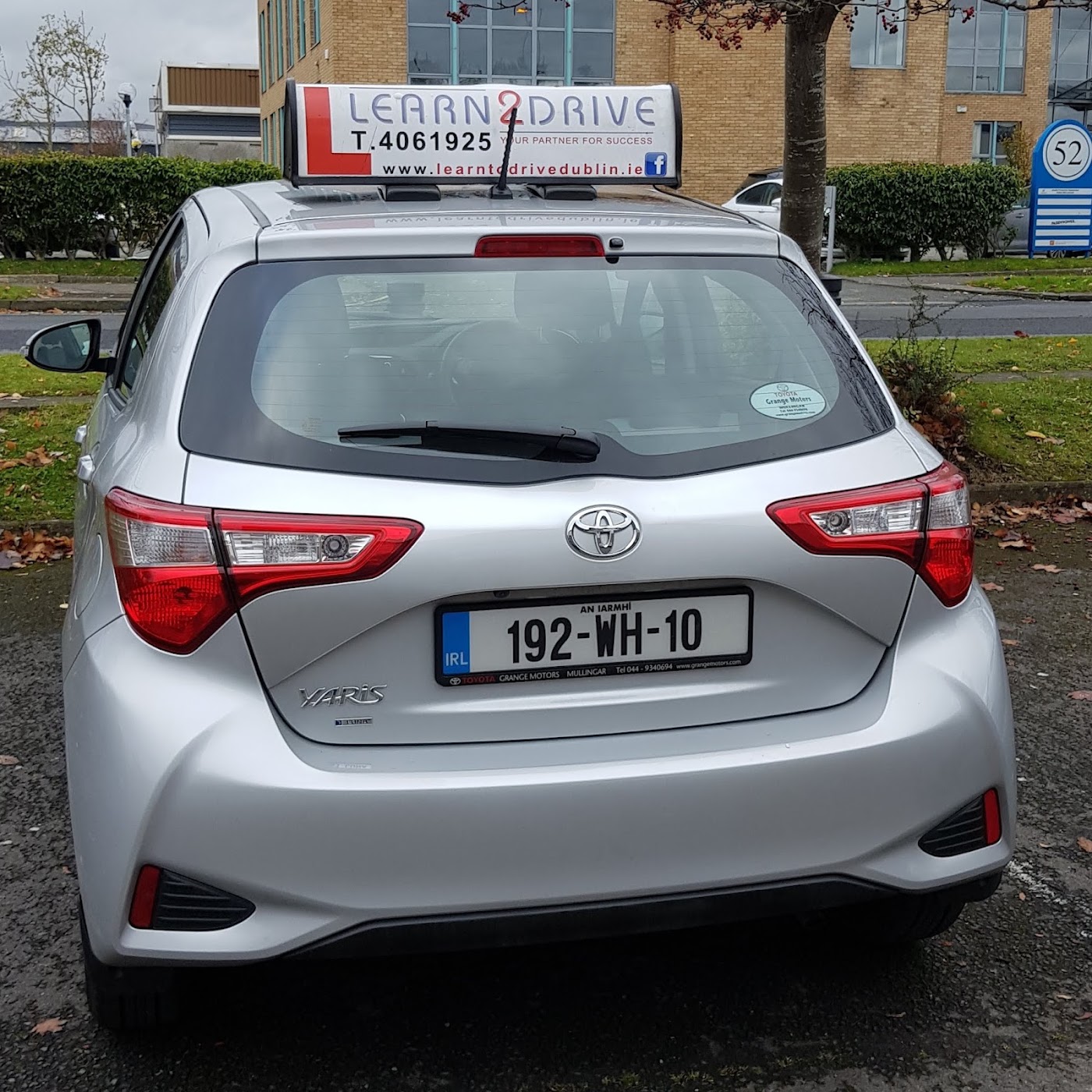 Pupil with their pass next to the Learn2Drive car